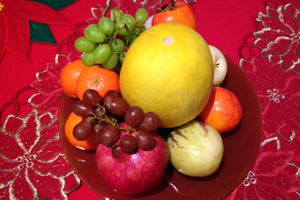 Ein Obstteller mit Trauben, Mandarinen, Granatapfel und Honigmelone